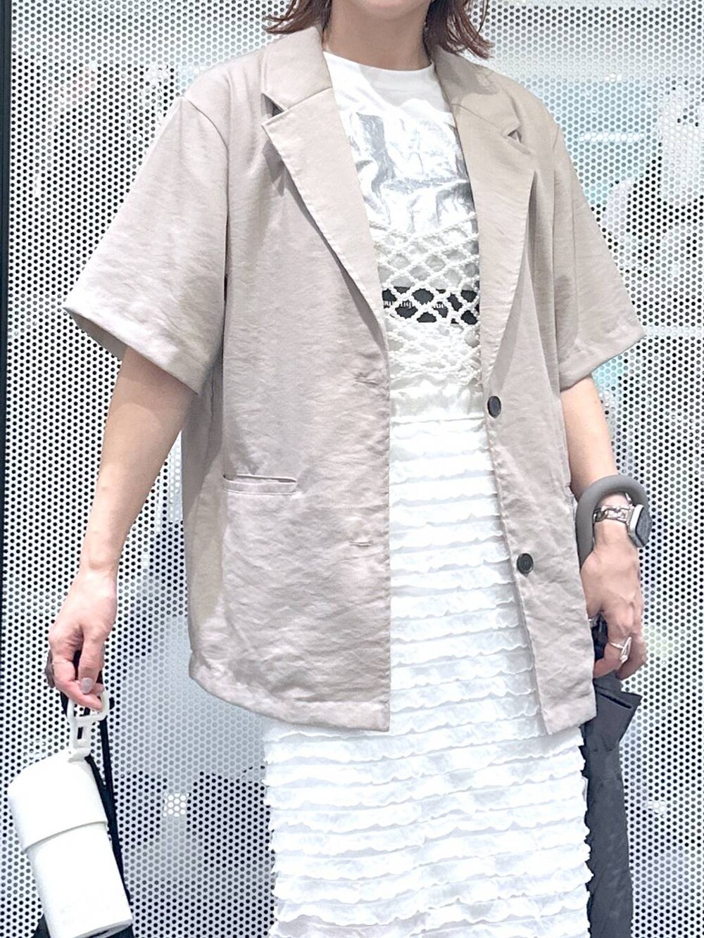 ブラック系のショルダーバッグ、ホワイト系のベスト、ホワイト系のTシャツ/カットソーを着用したレディースの夏コーディネートの5枚目の写真