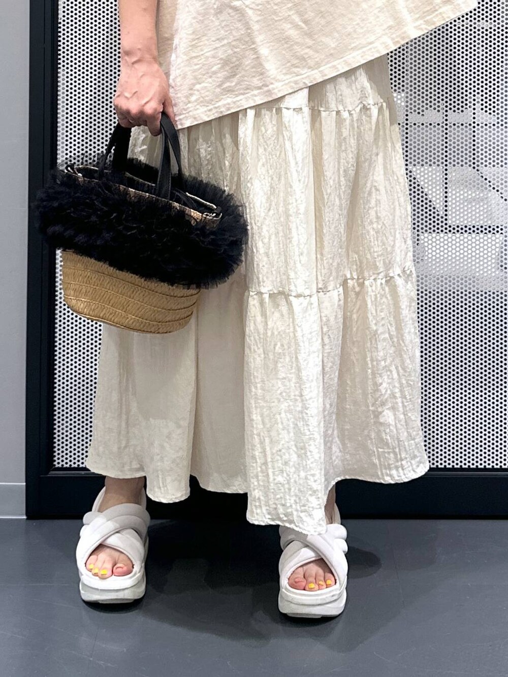 ベージュ系のショルダーバッグ、ホワイト系のスカート、ブラック系のバレッタ/ヘアクリップを着用したレディースの夏コーディネートの5枚目の写真