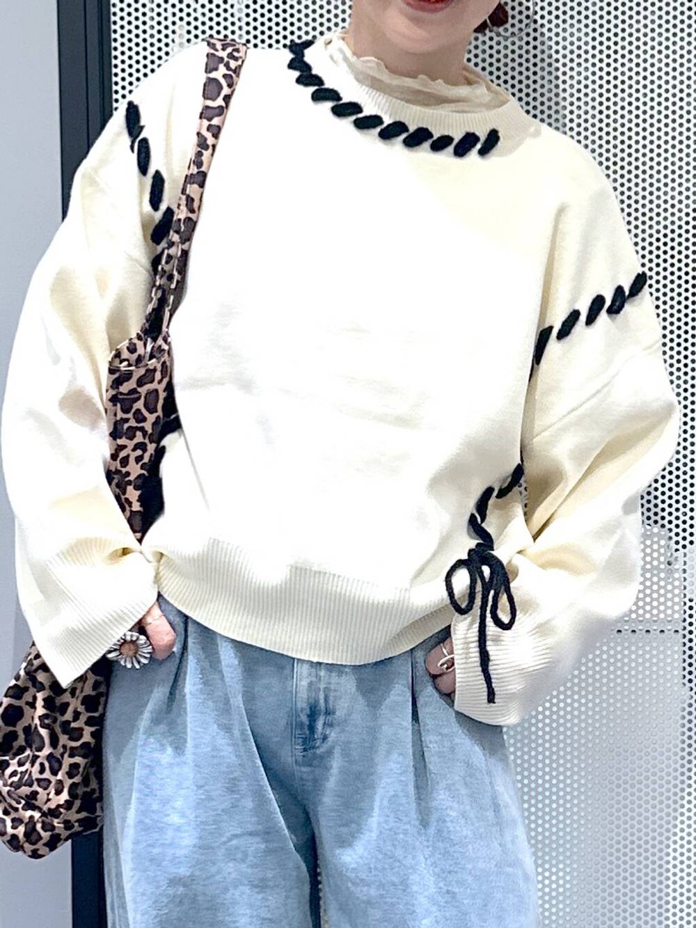 グレー系のスニーカー、ベージュ系のトートバッグ、ブルー系のデニムパンツを着用したレディースの秋コーディネートの5枚目の写真