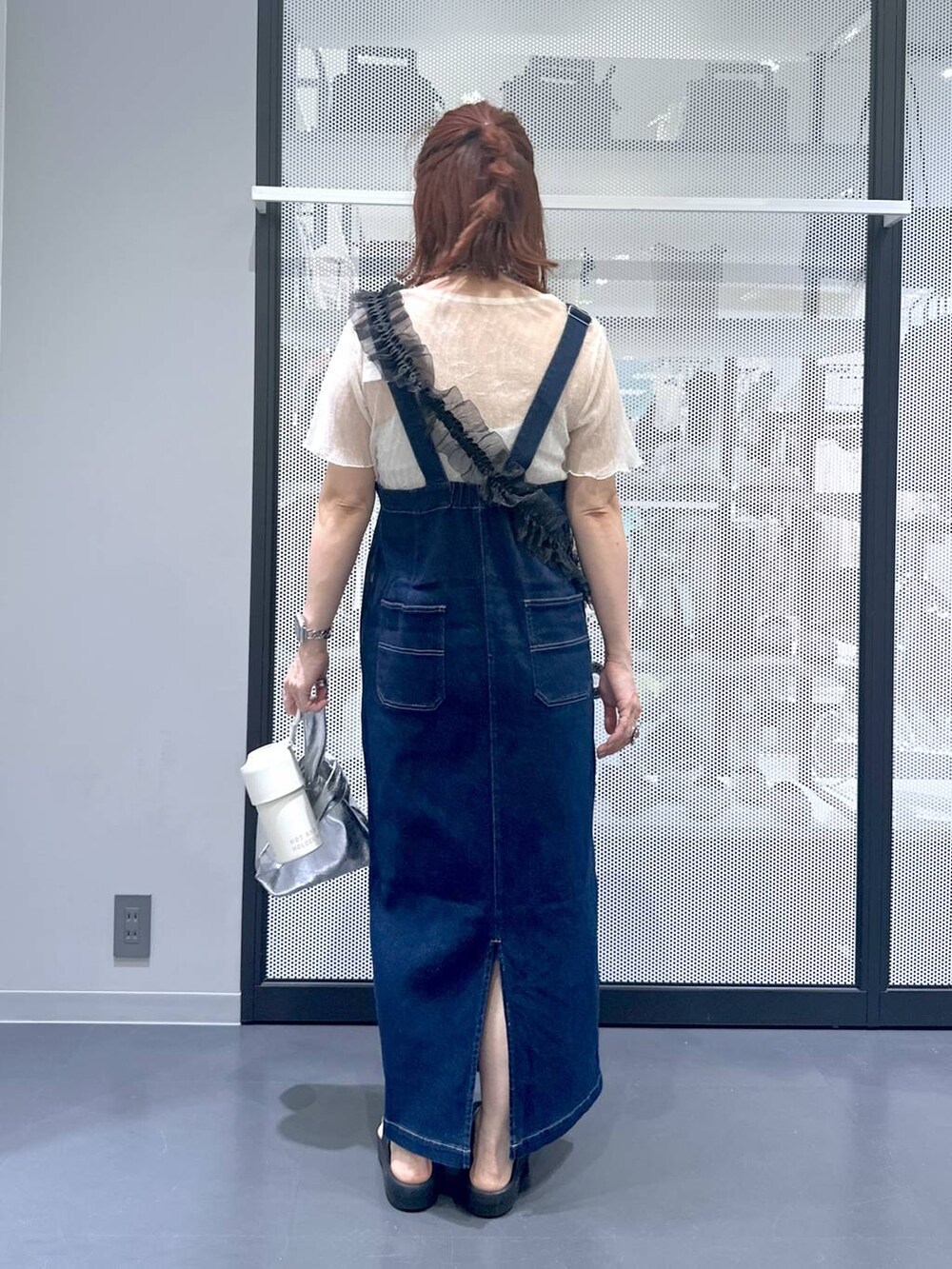 ブルー系のジャンパースカート、ブラック系のサンダル、ベージュ系のTシャツ/カットソーを着用したレディースの夏コーディネートの4枚目の写真