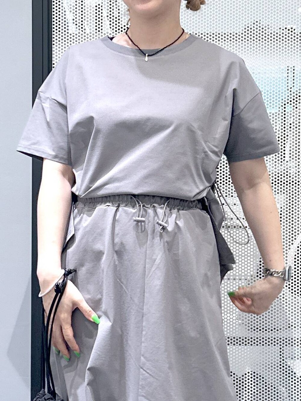 ブラック系のショルダーバッグ、グレー系のスカート、グレー系のTシャツ/カットソーを着用したレディースの春コーディネートの3枚目の写真