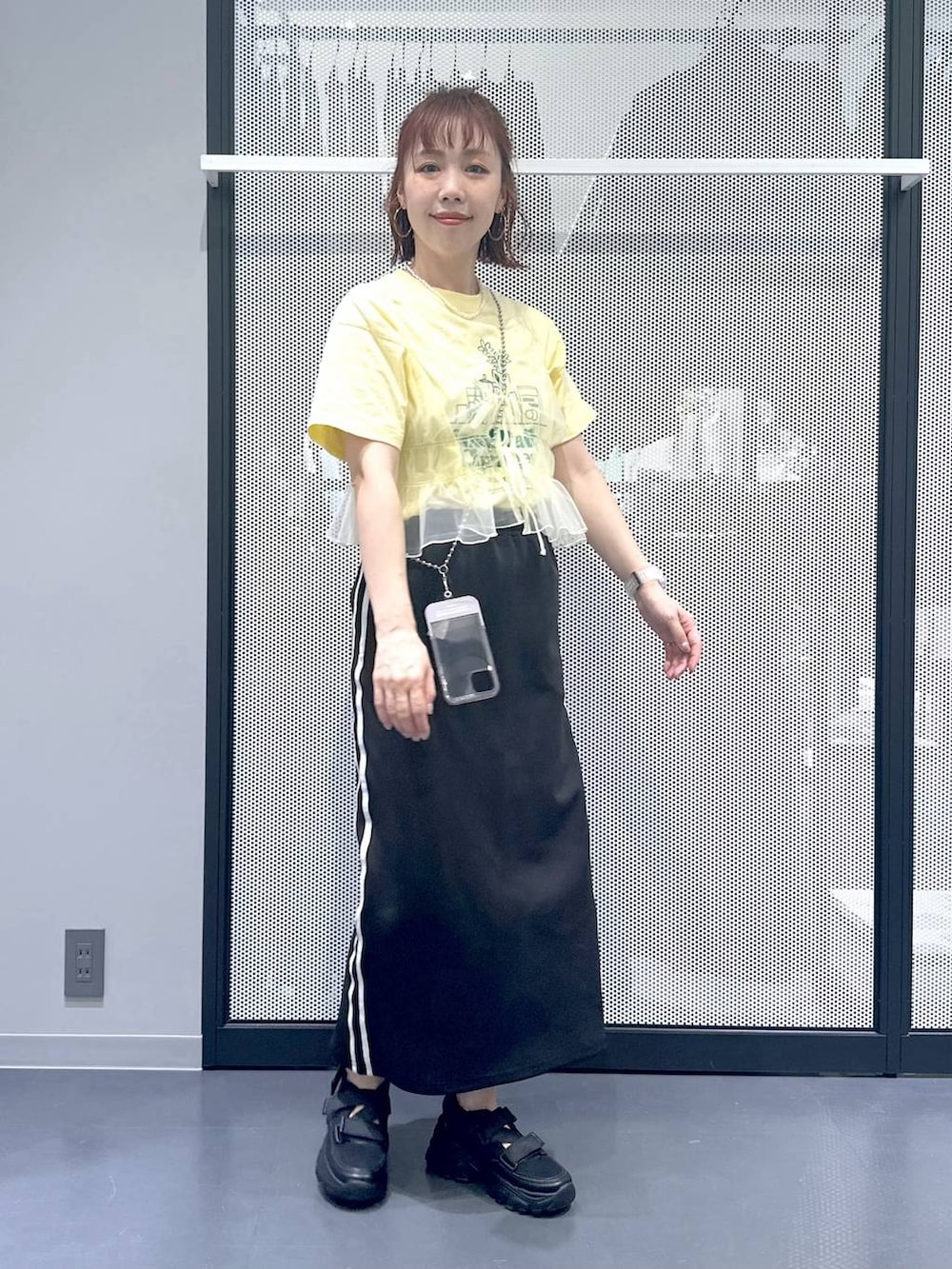 ブラック系のスカート、イエロー系のキャミソール、ベージュ系のTシャツ/カットソーを着用したレディースの春コーディネートの8枚目の写真