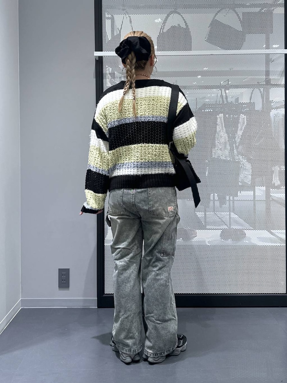 ブラック系のショルダーバッグ、ブラック系のニット/セーター、その他のピアス(両耳用)を着用したレディースの秋コーディネートの3枚目の写真