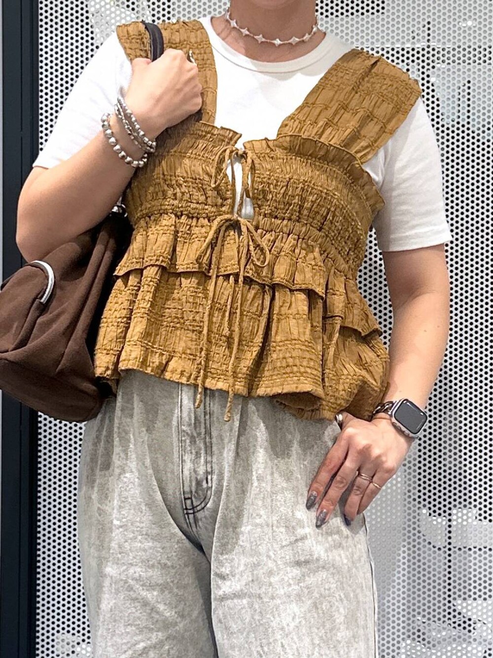 グレー系のデニムパンツ、ホワイト系のTシャツ/カットソー、ベージュ系のサンダルを着用したレディースの夏コーディネートの4枚目の写真