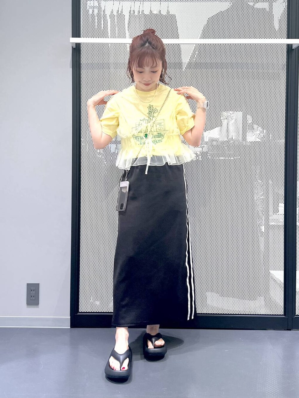 ブラック系のスカート、イエロー系のキャミソール、ベージュ系のTシャツ/カットソーを着用したレディースの春コーディネートの9枚目の写真