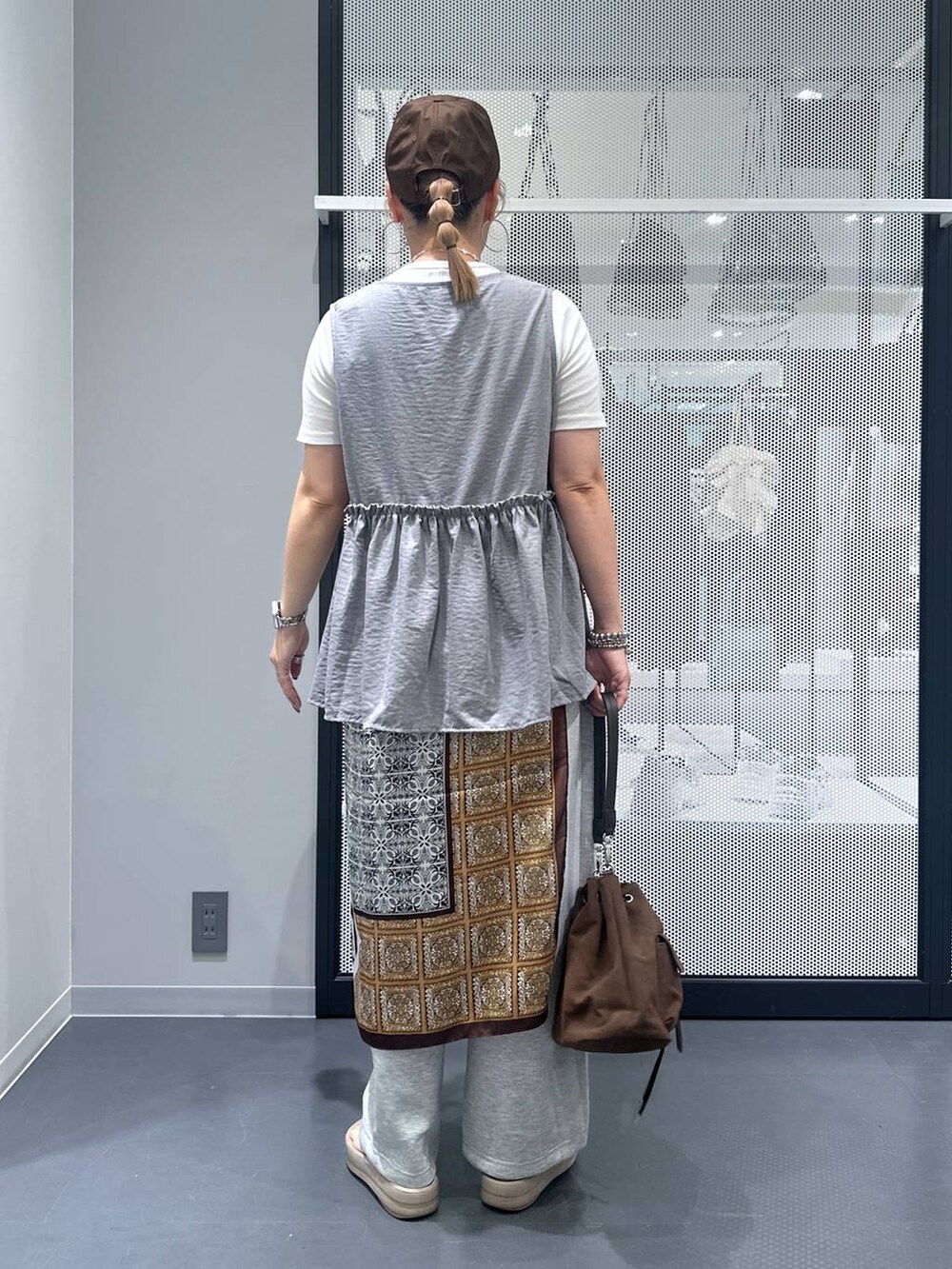 ホワイト系のTシャツ/カットソー、ブラウン系のショルダーバッグ、ベージュ系のサンダルを着用したレディースの夏コーディネートの3枚目の写真