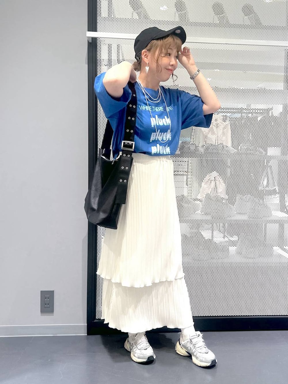 ブラック系のショルダーバッグ、ホワイト系のスカート、ブルー系のTシャツ/カットソーを着用したレディースの春コーディネートの2枚目の写真