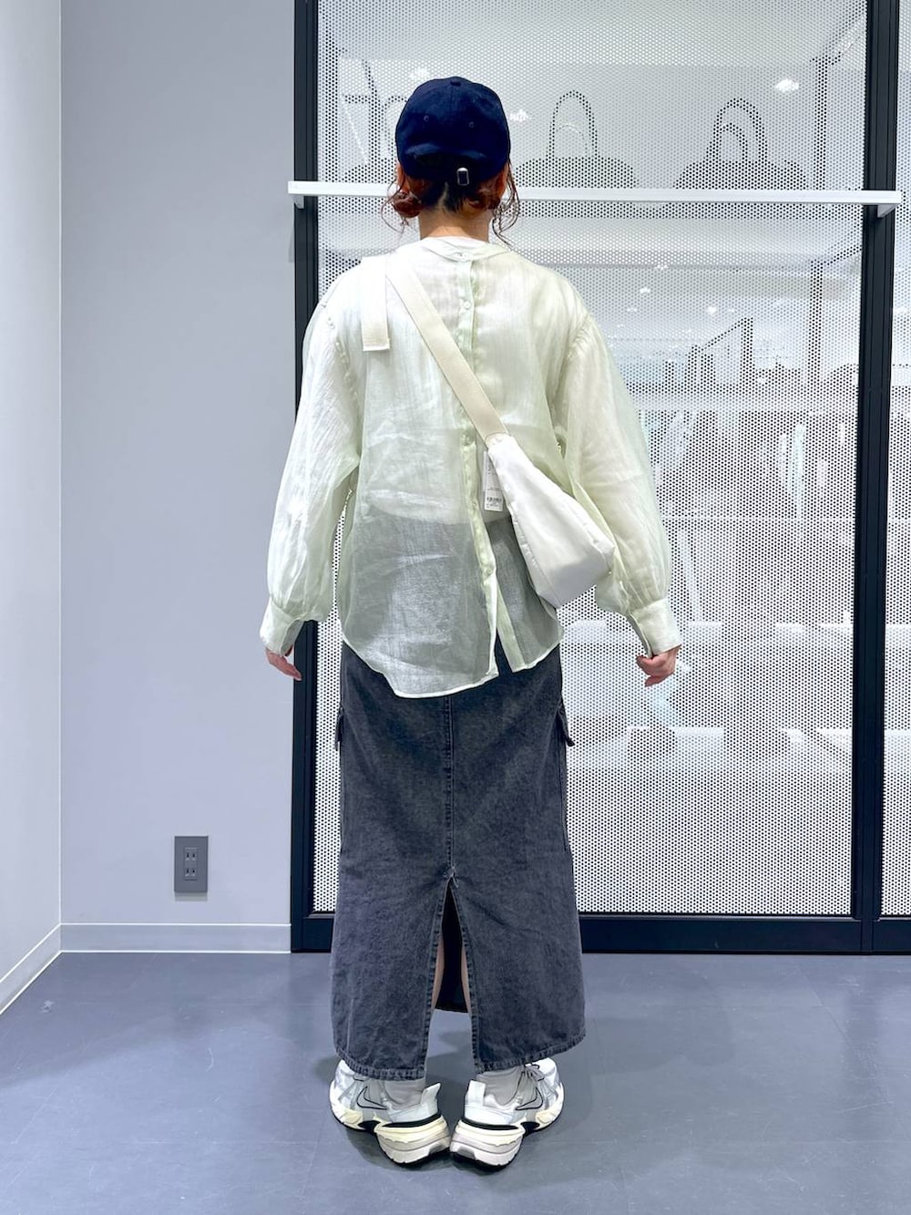 グレー系のデニムスカート、ホワイト系のTシャツ/カットソー、ホワイト系のショルダーバッグを着用したレディースの春コーディネートの4枚目の写真