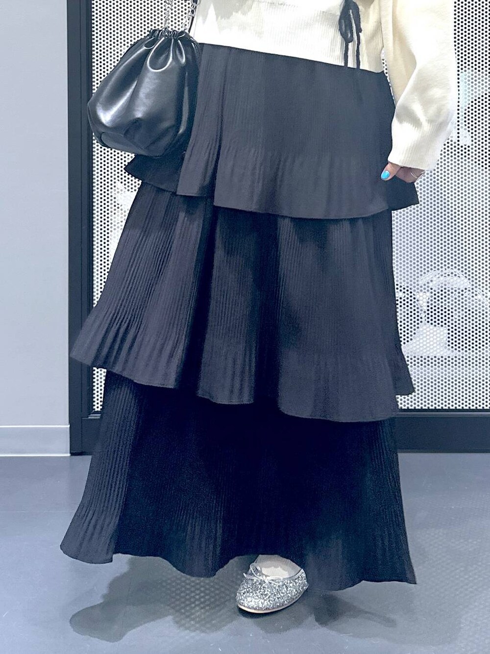 ブラック系のスカート、ブラック系のショルダーバッグ、シルバー系のパンプスを着用したレディースの秋コーディネートの5枚目の写真