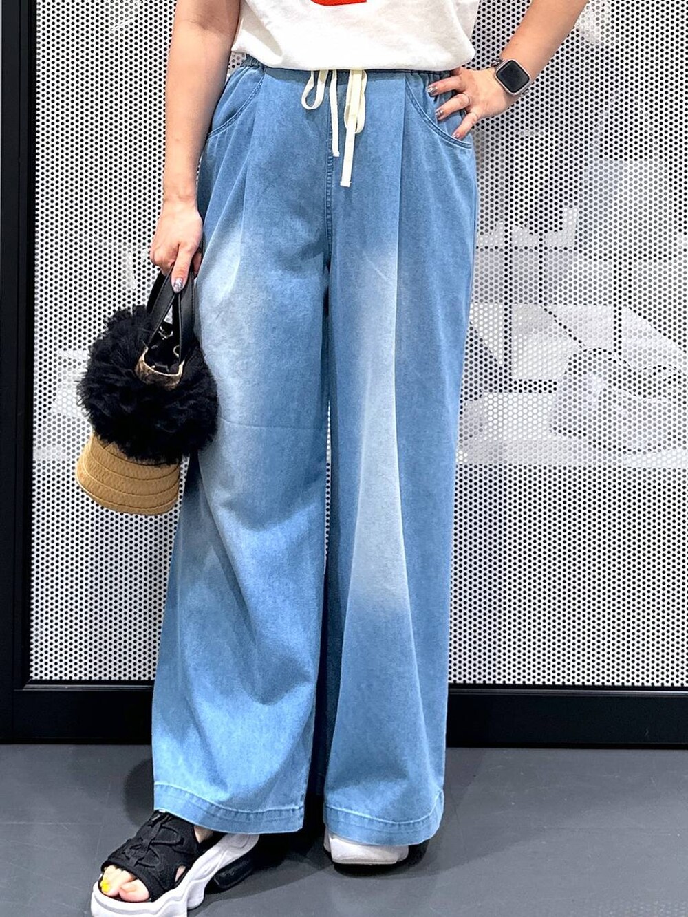 ベージュ系のショルダーバッグ、ブルー系のデニムパンツ、ホワイト系のTシャツ/カットソーを着用したレディースの夏コーディネートの7枚目の写真