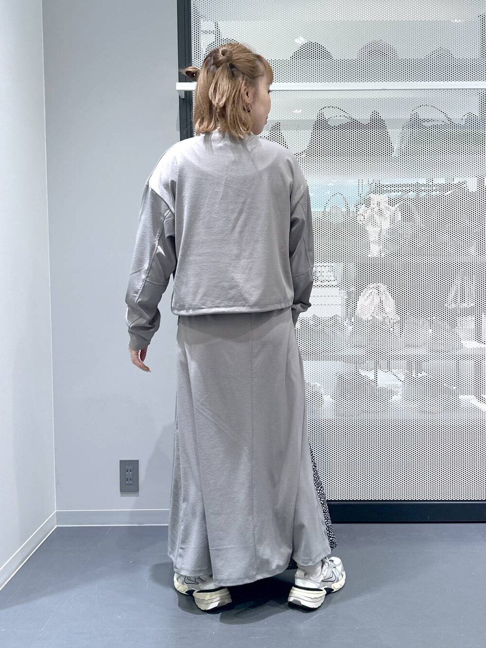 グレー系のスカート、グレー系のTシャツ/カットソー、ブラック系のトートバッグを着用したレディースの春コーディネートの3枚目の写真