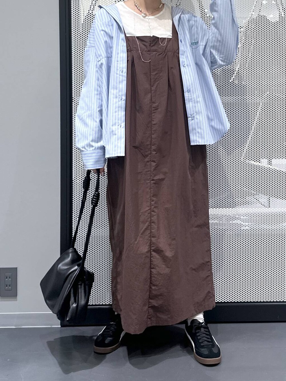 ホワイト系のTシャツ/カットソー、ブラック系のスニーカー、ブラック系のショルダーバッグを着用したレディースの秋コーディネートの5枚目の写真