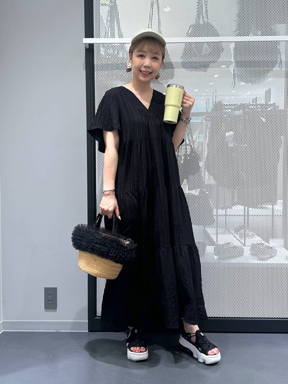 ベージュ系のショルダーバッグ、ブラック系のワンピース、ブラック系のサンダルを着用したレディースの春コーディネートの5枚目の写真