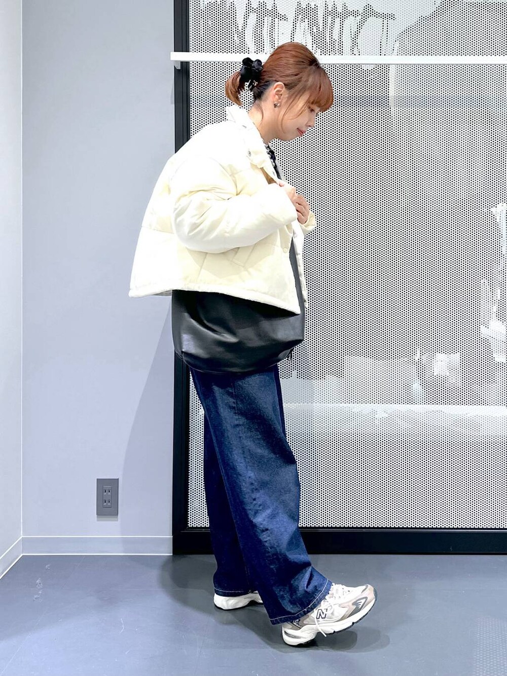 ブラウン系のスニーカー、ホワイト系のTシャツ/カットソー、ブルー系のデニムパンツを着用したレディースの冬コーディネートの9枚目の写真