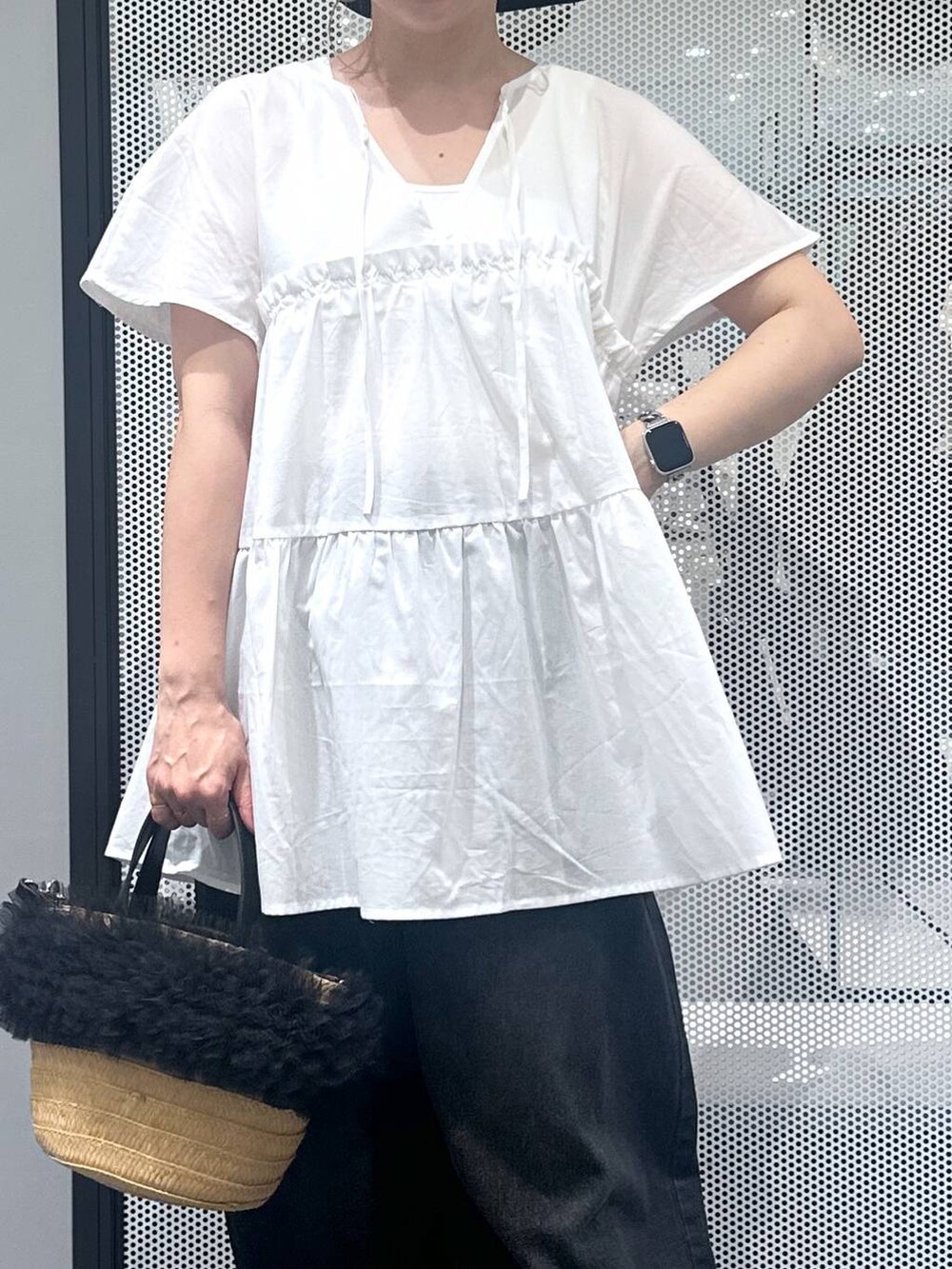ブラック系のデニムパンツ、ベージュ系のショルダーバッグ、ホワイト系のタンクトップを着用したレディースの夏コーディネートの3枚目の写真
