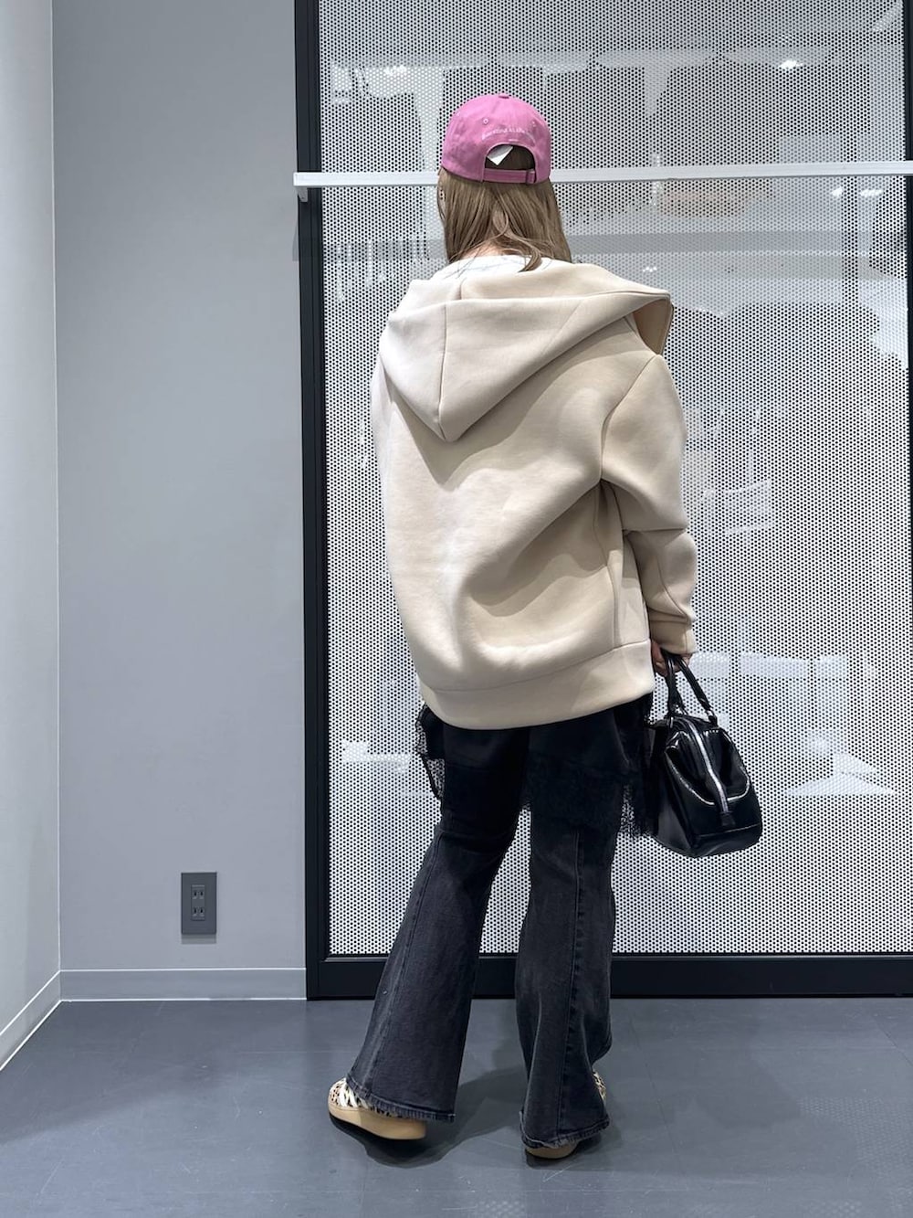 ブラック系のショルダーバッグ、ホワイト系のTシャツ/カットソー、ブラック系のデニムパンツを着用したレディースの冬コーディネートの2枚目の写真