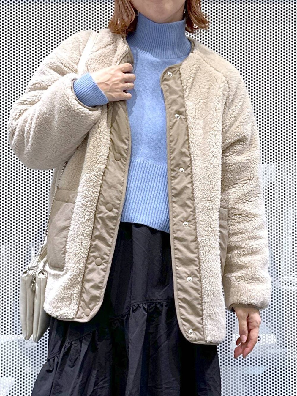 ホワイト系のショルダーバッグ、ブラック系のローファー、ベージュ系のブルゾンを着用したレディースの冬コーディネートの5枚目の写真