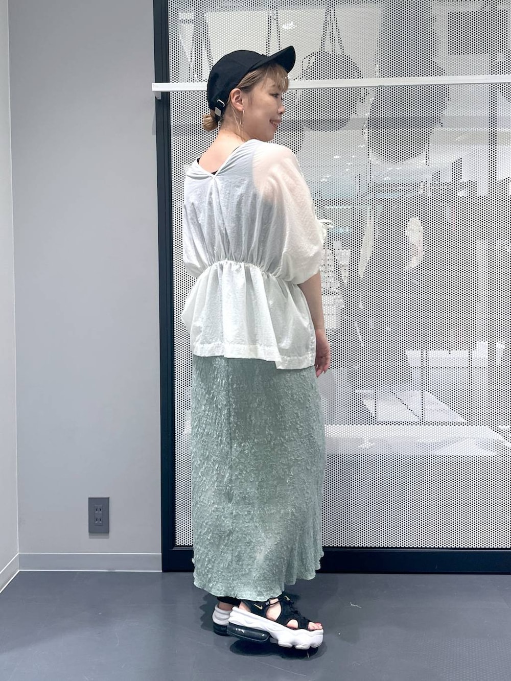 ブラック系のタンクトップ、グレー系のショルダーバッグ、グリーン系のスカートを着用したレディースの夏コーディネートの3枚目の写真