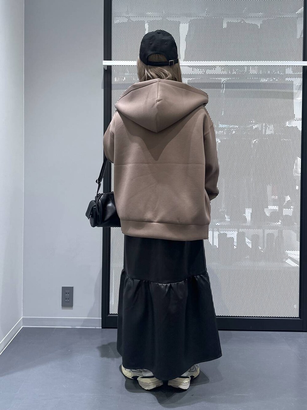 ブラウン系のパーカー、その他のピアス(両耳用)、ブルー系のキャップを着用したレディースの秋コーディネートの4枚目の写真