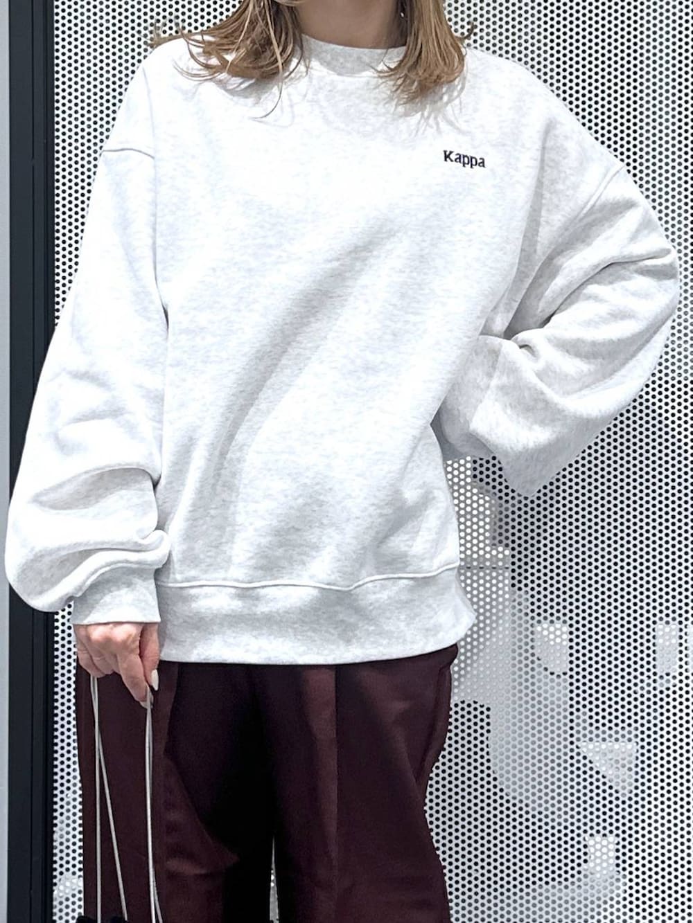 グレー系のベスト、ブラック系のショルダーバッグ、レッド系のスラックスを着用したレディースの秋コーディネートの4枚目の写真