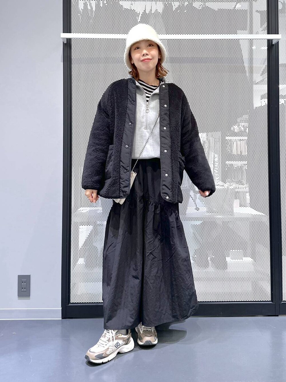 ブラウン系のスニーカー、ホワイト系のショルダーバッグ、その他のニット/セーターを着用したレディースの冬コーディネートの3枚目の写真