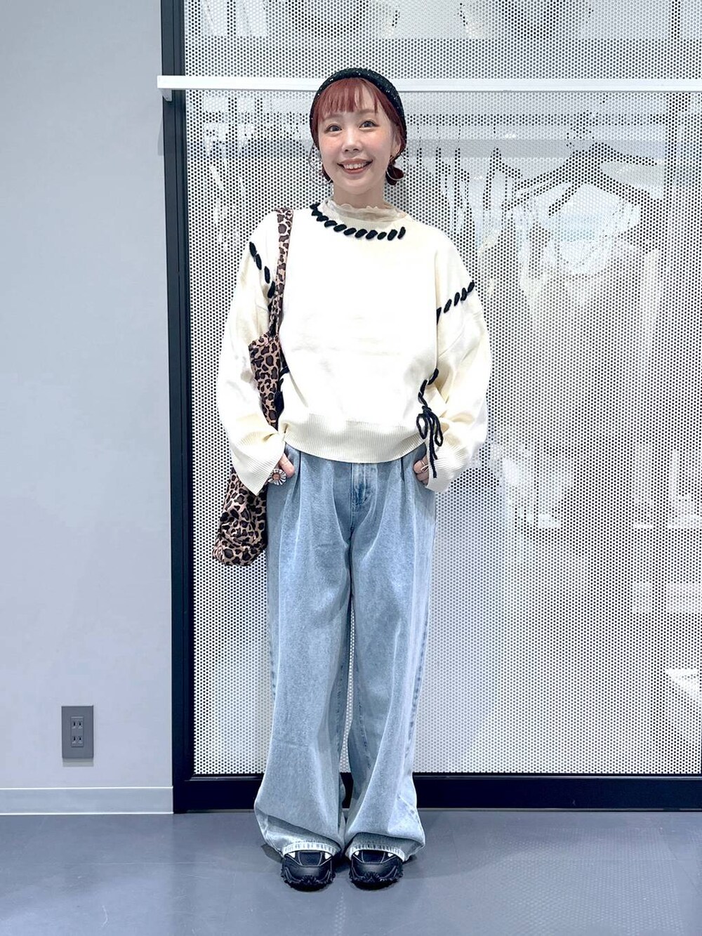 グレー系のスニーカー、ベージュ系のトートバッグ、ブルー系のデニムパンツを着用したレディースの秋コーディネートの4枚目の写真