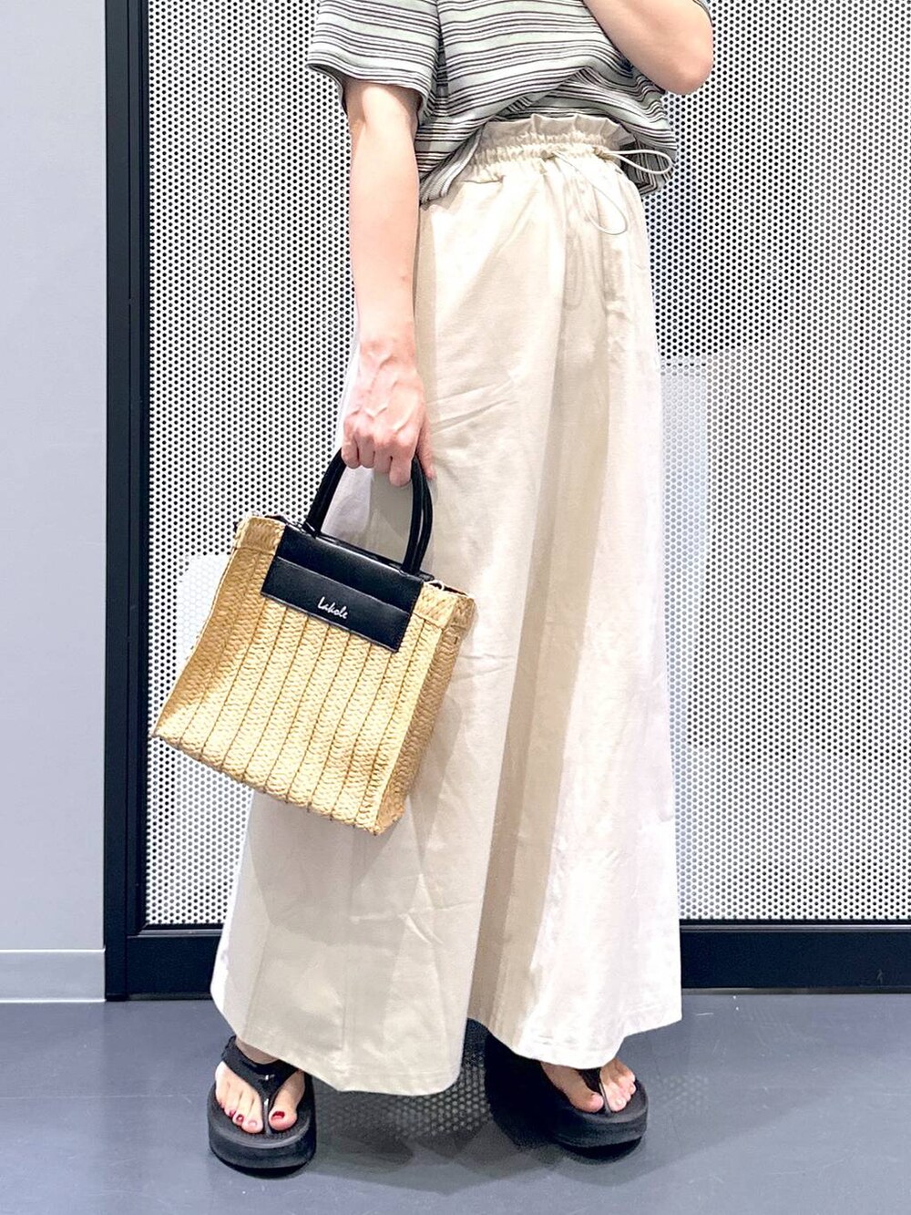 ベージュ系のスカート、ブラック系のサンダル、ベージュ系のショルダーバッグを着用したレディースの夏コーディネートの5枚目の写真