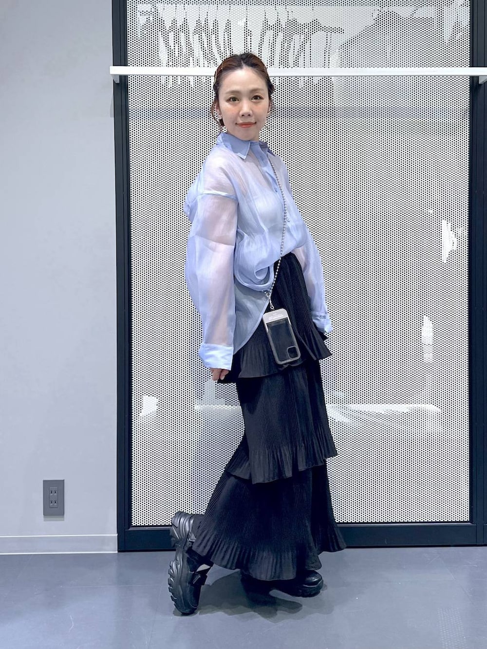 ブラック系のスニーカー、ブラック系のスカート、ブルー系のシャツ/ブラウスを着用したレディースの春コーディネートの7枚目の写真