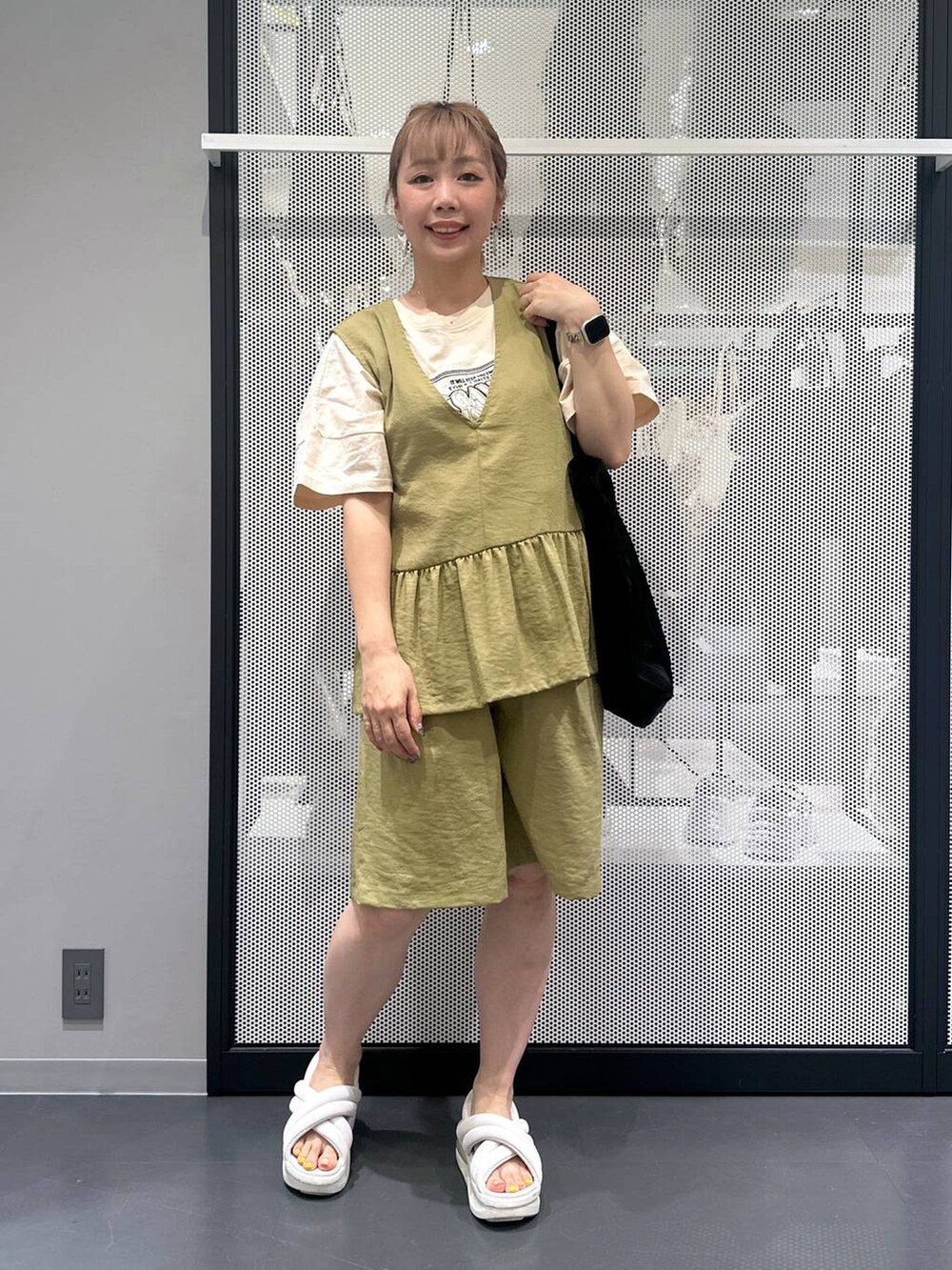 グリーン系のベスト、グリーン系のその他パンツ、ブラック系のトートバッグを着用したレディースの夏コーディネートの2枚目の写真