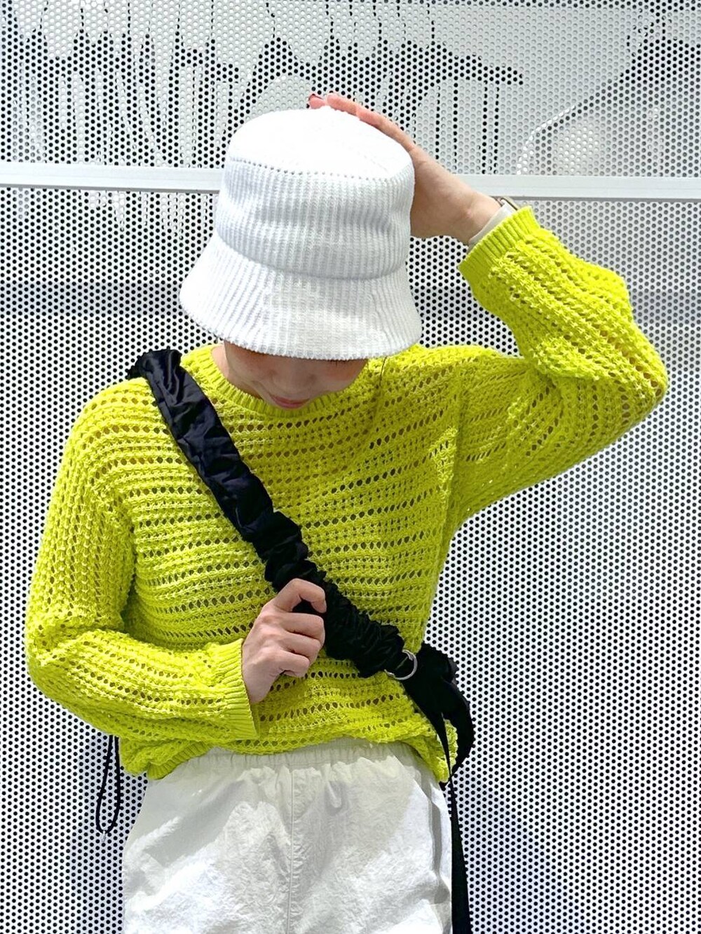 ブラック系のスニーカー、ホワイト系のカーゴパンツ、グリーン系のニット/セーターを着用したレディースの春コーディネートの4枚目の写真