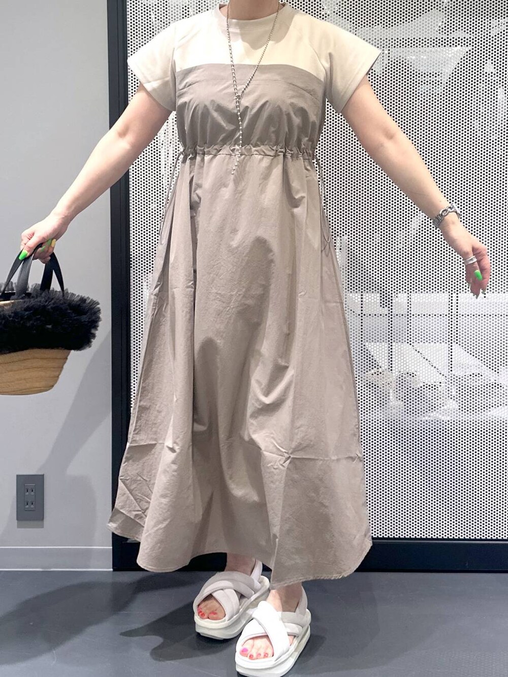 ベージュ系のショルダーバッグ、ベージュ系のワンピース、ホワイト系のサンダルを着用したレディースの春コーディネートの4枚目の写真