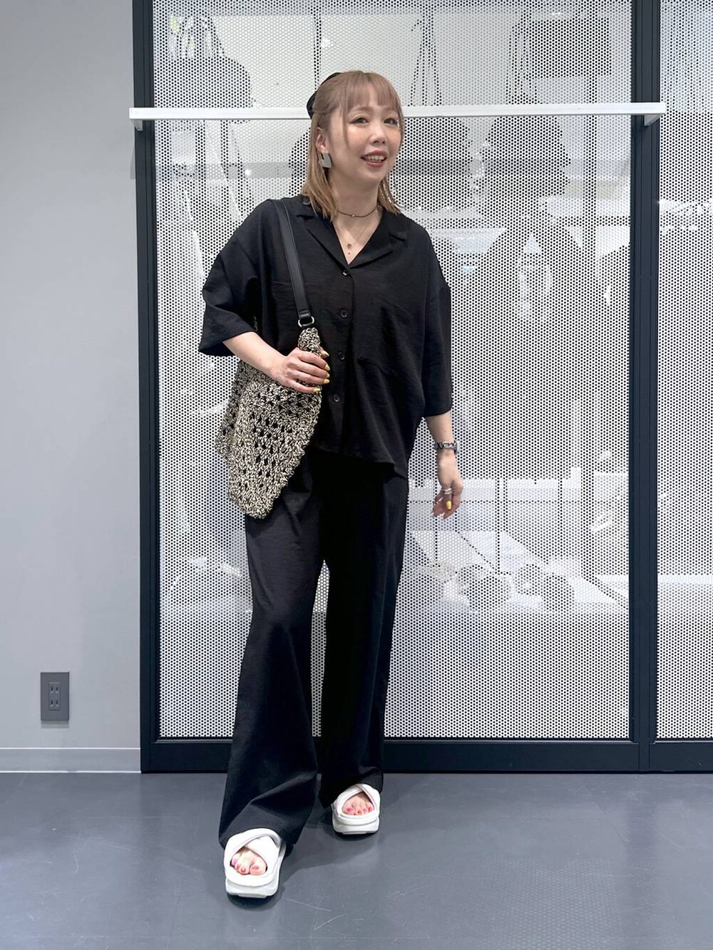 ブラック系のトートバッグ、ブラック系のその他パンツ、ブラック系のシャツ/ブラウスを着用したレディースの春コーディネートの5枚目の写真