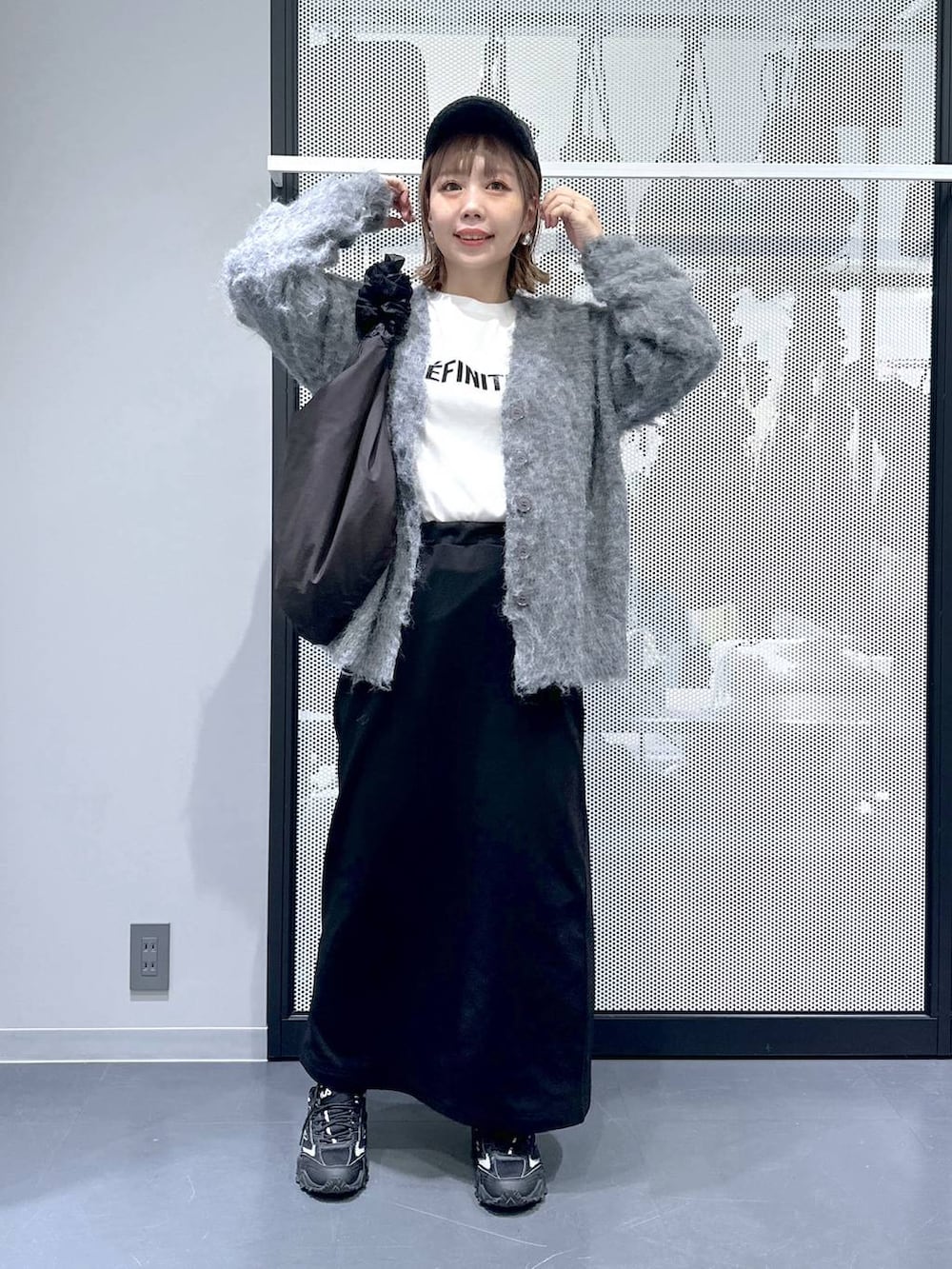 グレー系のスニーカー、グレー系のカーディガン/ボレロ、ブラック系のショルダーバッグを着用したレディースの冬コーディネートの2枚目の写真