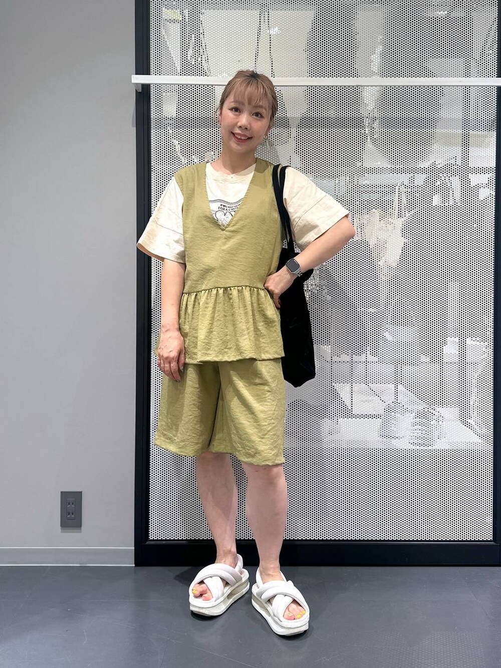 グリーン系のベスト、グリーン系のその他パンツ、ブラック系のトートバッグを着用したレディースの夏コーディネートの4枚目の写真