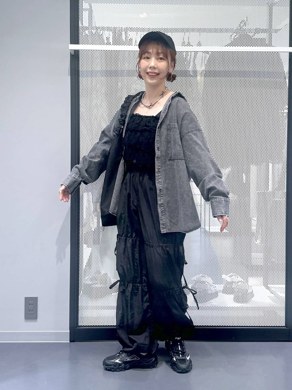 グレー系のスニーカー、ブラック系のショルダーバッグ、ブラック系のその他パンツを着用したレディースの秋コーディネートの2枚目の写真