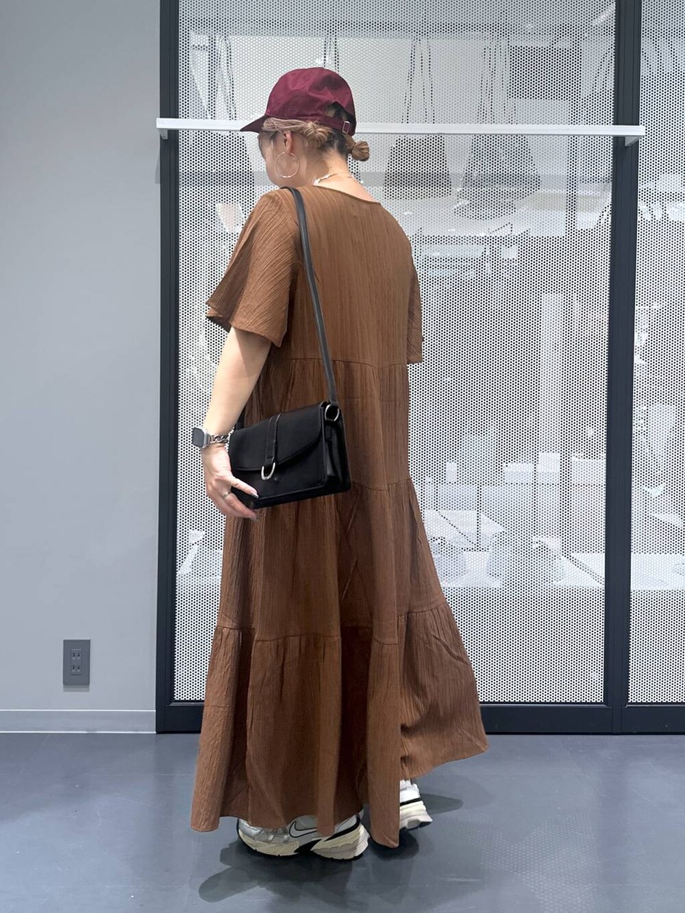 ブラック系のショルダーバッグ、その他のピアス（両耳用）、シルバー系のデジタル腕時計を着用したレディースの夏コーディネートの3枚目の写真