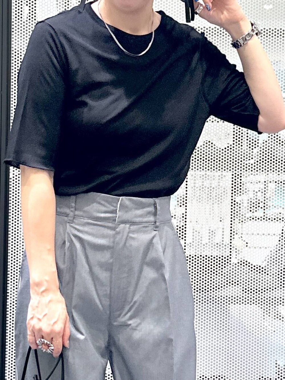 ブラック系のTシャツ/カットソー、グレー系のスラックス、ブラック系のサンダルを着用したレディースの夏コーディネートの4枚目の写真