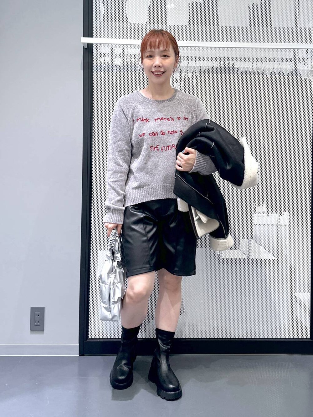 ブラック系のブルゾン、ブラック系のブーツ、シルバー系のショルダーバッグを着用したレディースの秋コーディネートの4枚目の写真