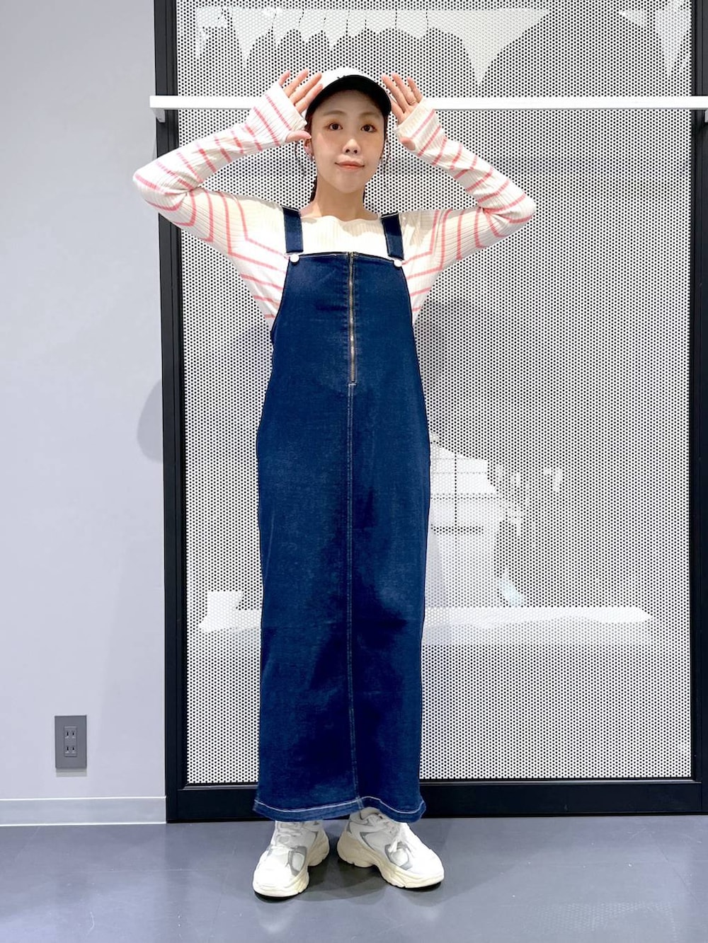 ブルー系のジャンパースカート、ベージュ系のMA-1、ピンク系のニット/セーターを着用したレディースの春コーディネートの2枚目の写真