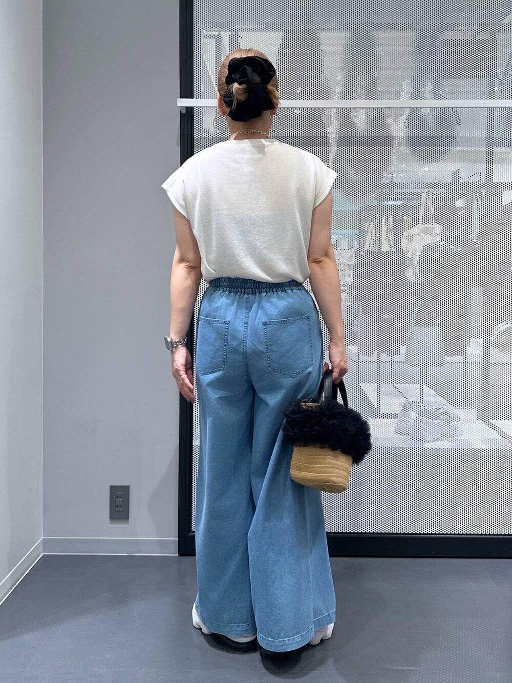 ベージュ系のショルダーバッグ、ブルー系のデニムパンツ、ホワイト系のTシャツ/カットソーを着用したレディースの夏コーディネートの3枚目の写真