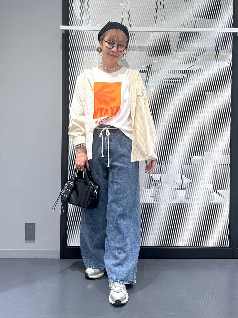 ブラック系のショルダーバッグ、ブルー系のデニムパンツ、ホワイト系のTシャツ/カットソーを着用したレディースの夏コーディネートの6枚目の写真