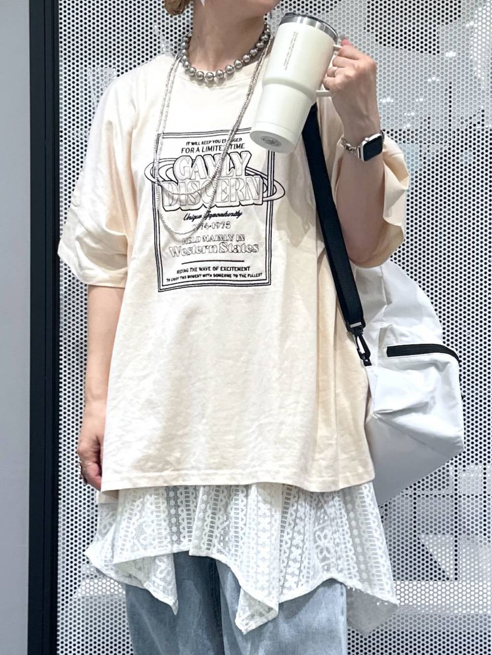 ホワイト系のショルダーバッグ、ブルー系のデニムパンツ、ベージュ系のワンピースを着用したレディースの夏コーディネートの4枚目の写真