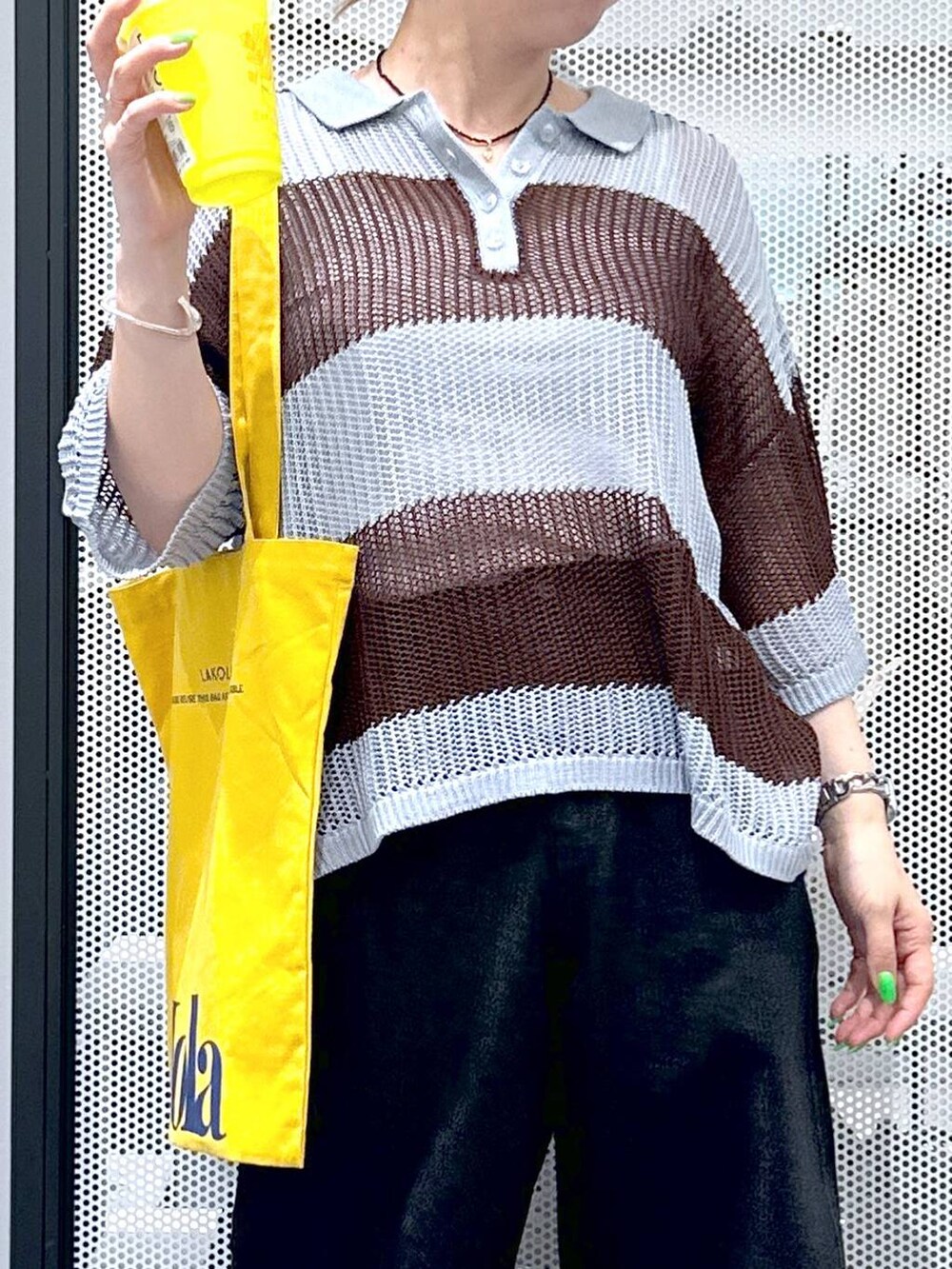 ブラック系のデニムパンツ、イエロー系のトートバッグ、ブルー系のニット/セーターを着用したレディースの春コーディネートの4枚目の写真