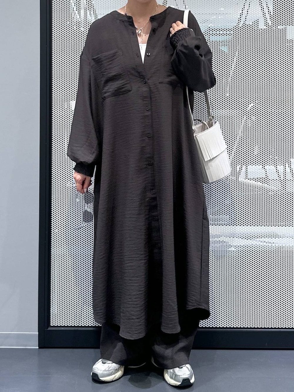 グレー系のその他パンツ、ホワイト系のタンクトップ、ホワイト系のショルダーバッグを着用したレディースの秋コーディネートの4枚目の写真