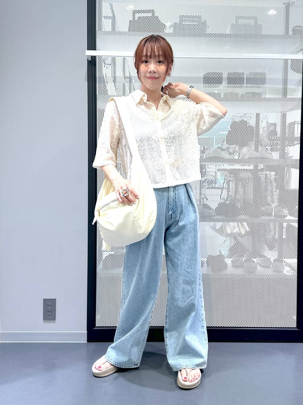 ベージュ系のシャツ/ブラウス、ブルー系のデニムパンツ、ホワイト系のショルダーバッグを着用したレディースの夏コーディネートの2枚目の写真