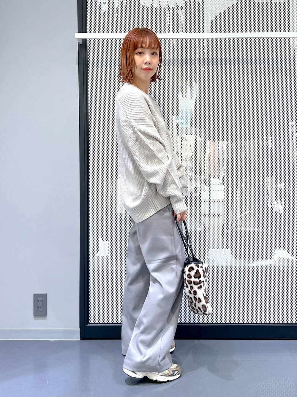 ブラウン系のスニーカー、グレー系のカーディガン/ボレロ、その他のショルダーバッグを着用したレディースの冬コーディネートの2枚目の写真