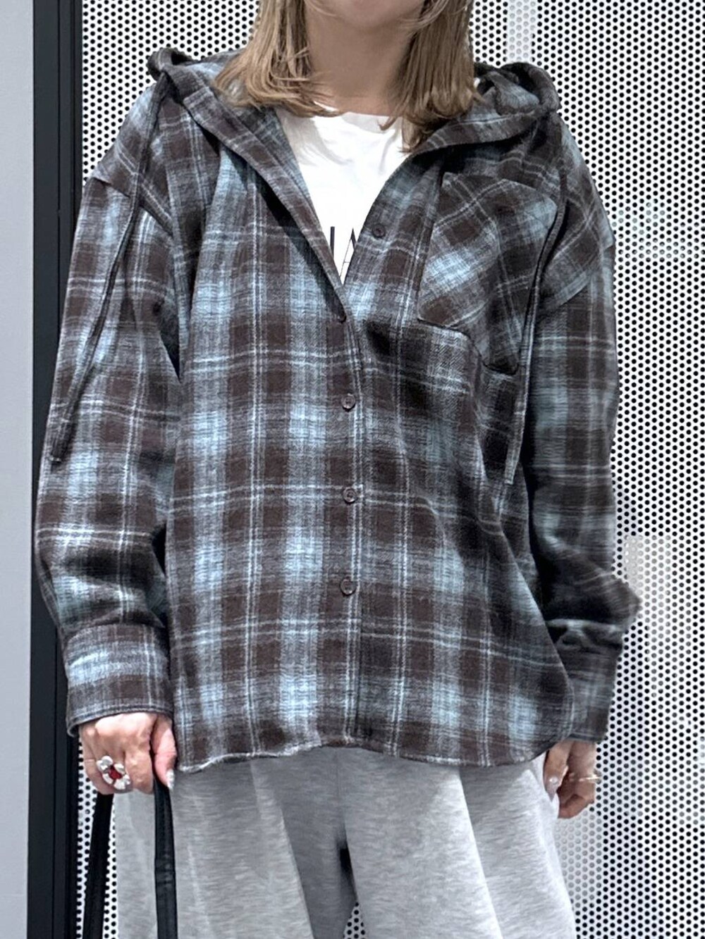 ブラック系のショルダーバッグ、ホワイト系のTシャツ/カットソー、グレー系のスウェットパンツを着用したレディースの秋コーディネートの4枚目の写真