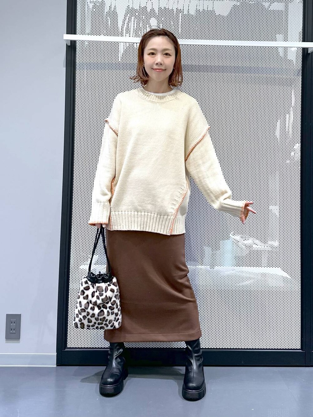 ホワイト系のブルゾン、その他のショルダーバッグ、ブラック系のブーツを着用したレディースの冬コーディネートの2枚目の写真