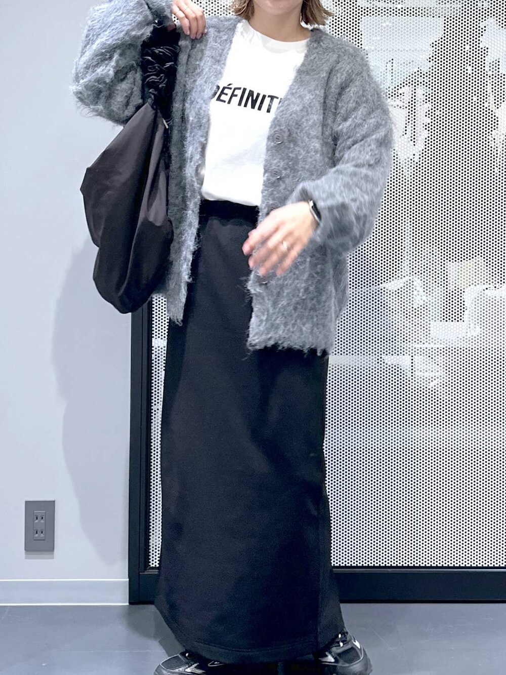 グレー系のスニーカー、グレー系のカーディガン/ボレロ、ブラック系のショルダーバッグを着用したレディースの冬コーディネートの4枚目の写真