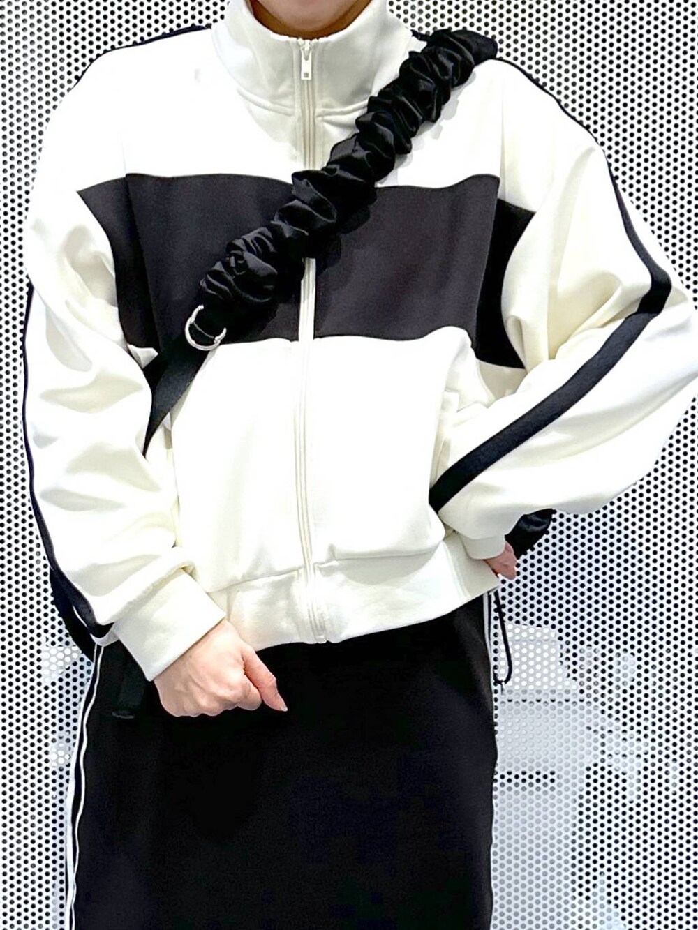 ブラック系のスカート、ベージュ系のブルゾン、ホワイト系のスニーカーを着用したレディースの冬コーディネートの5枚目の写真